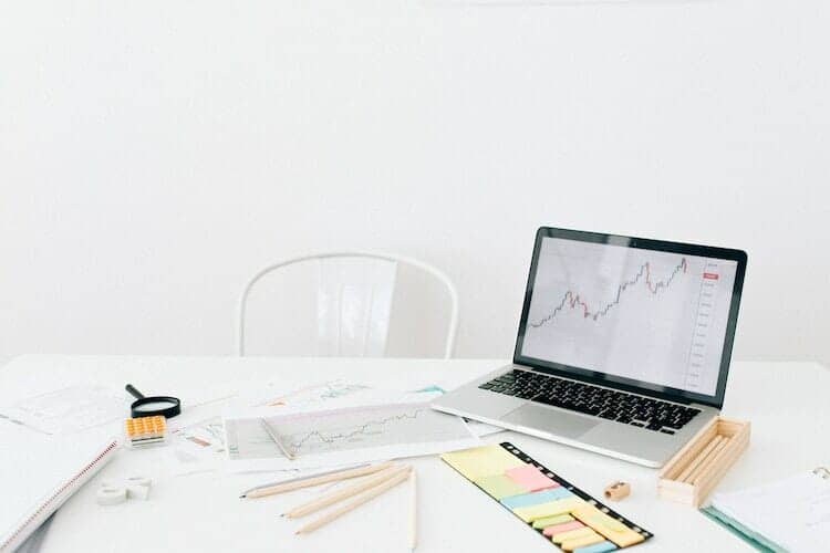 Desk with tools, computer with graph, and other ways of searching for a certified business broker in Los Angeles, California.